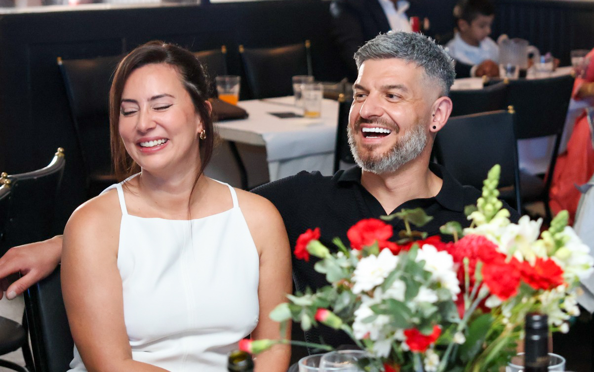 Couple laughing together at a birthday dinner table