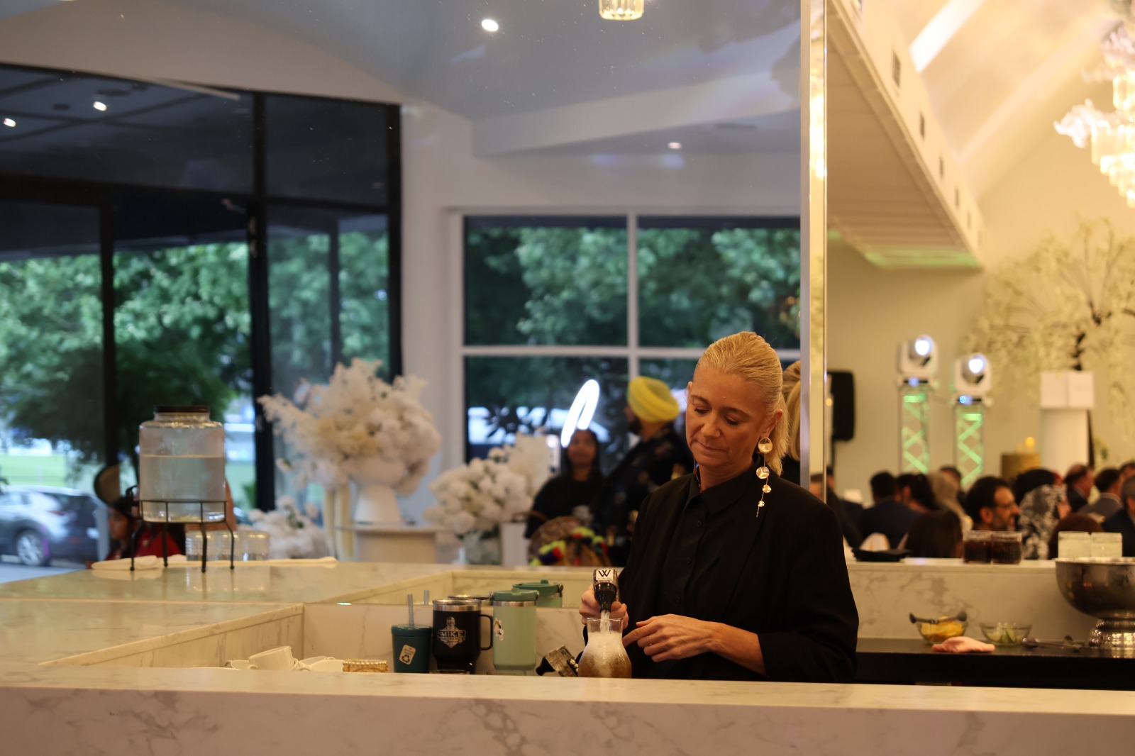 Chef preparing food at a marble bar in a bright event venue