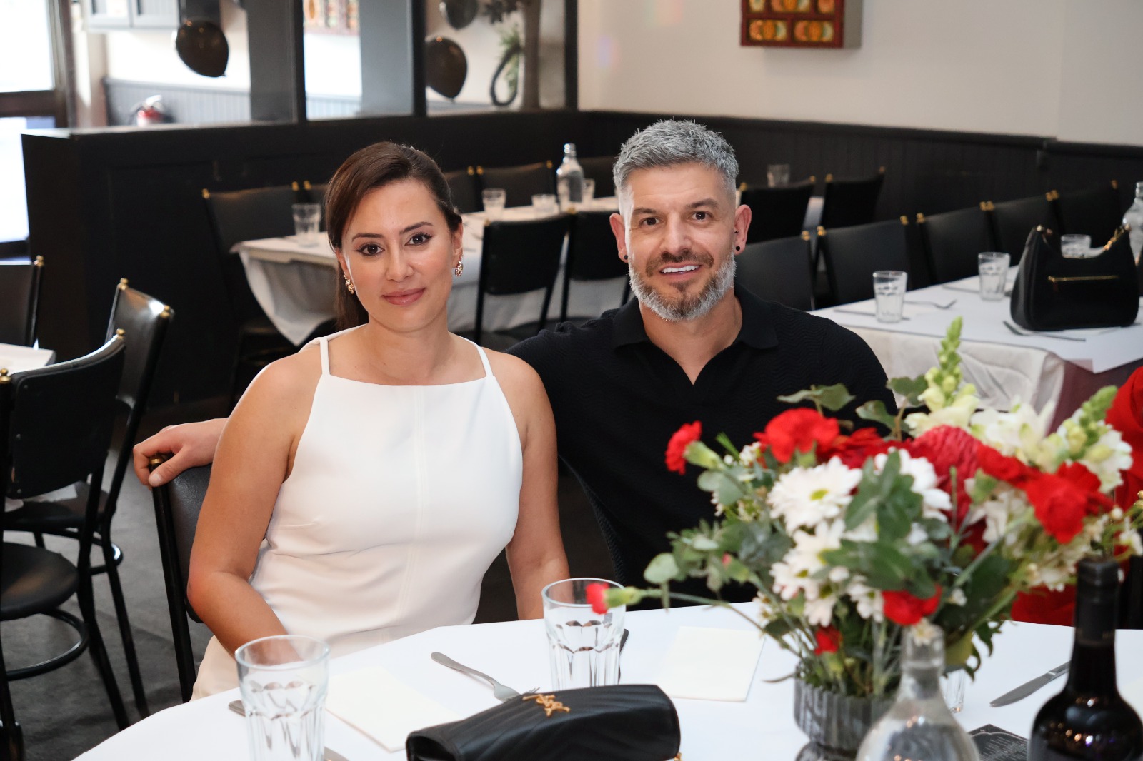 Couple seated at a dinner table with flowers