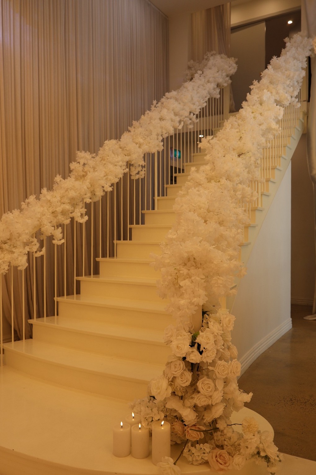 Staircase lined with white flowers and candles