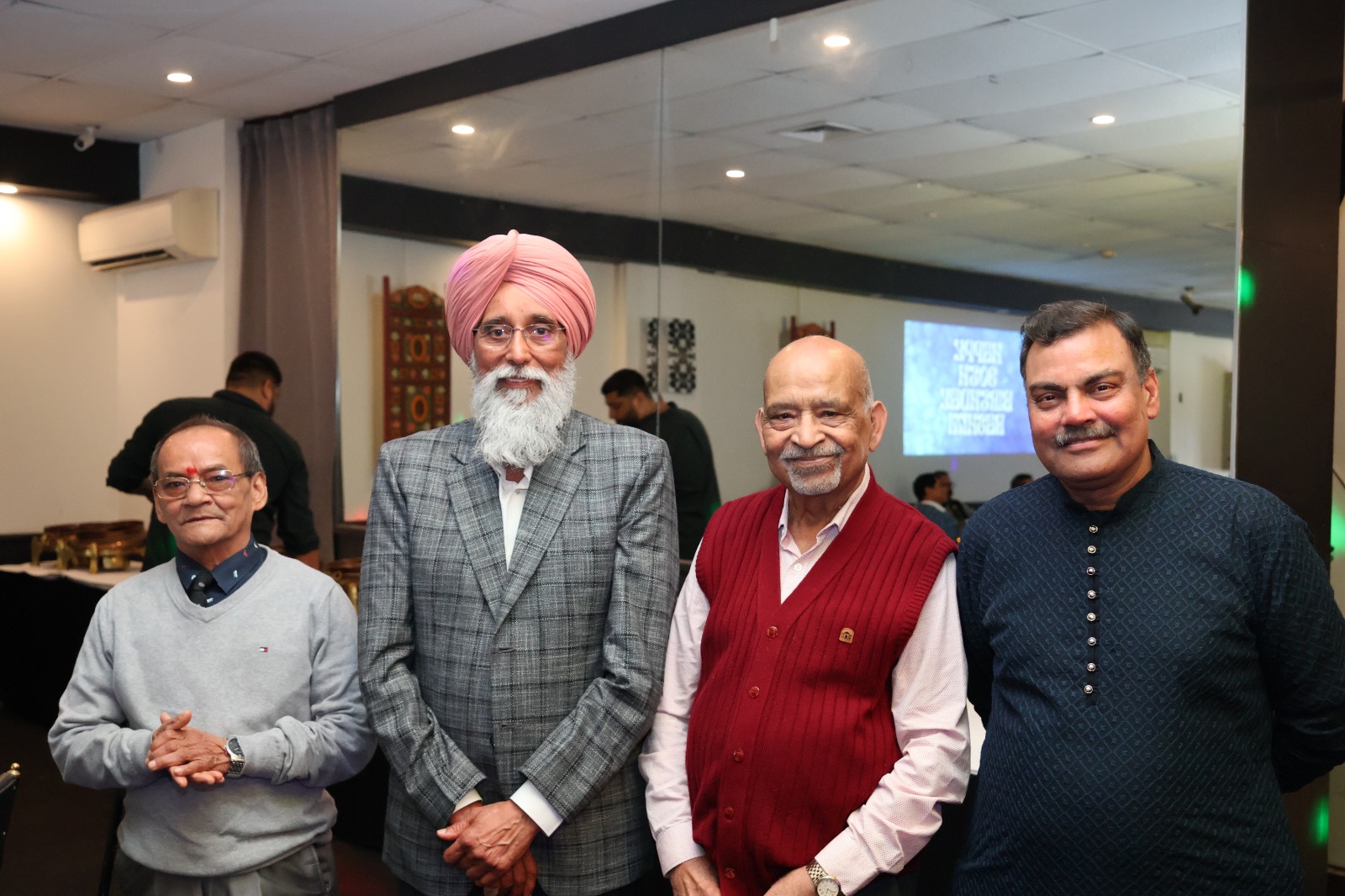 Four gentlemen posing together at a birthday celebration