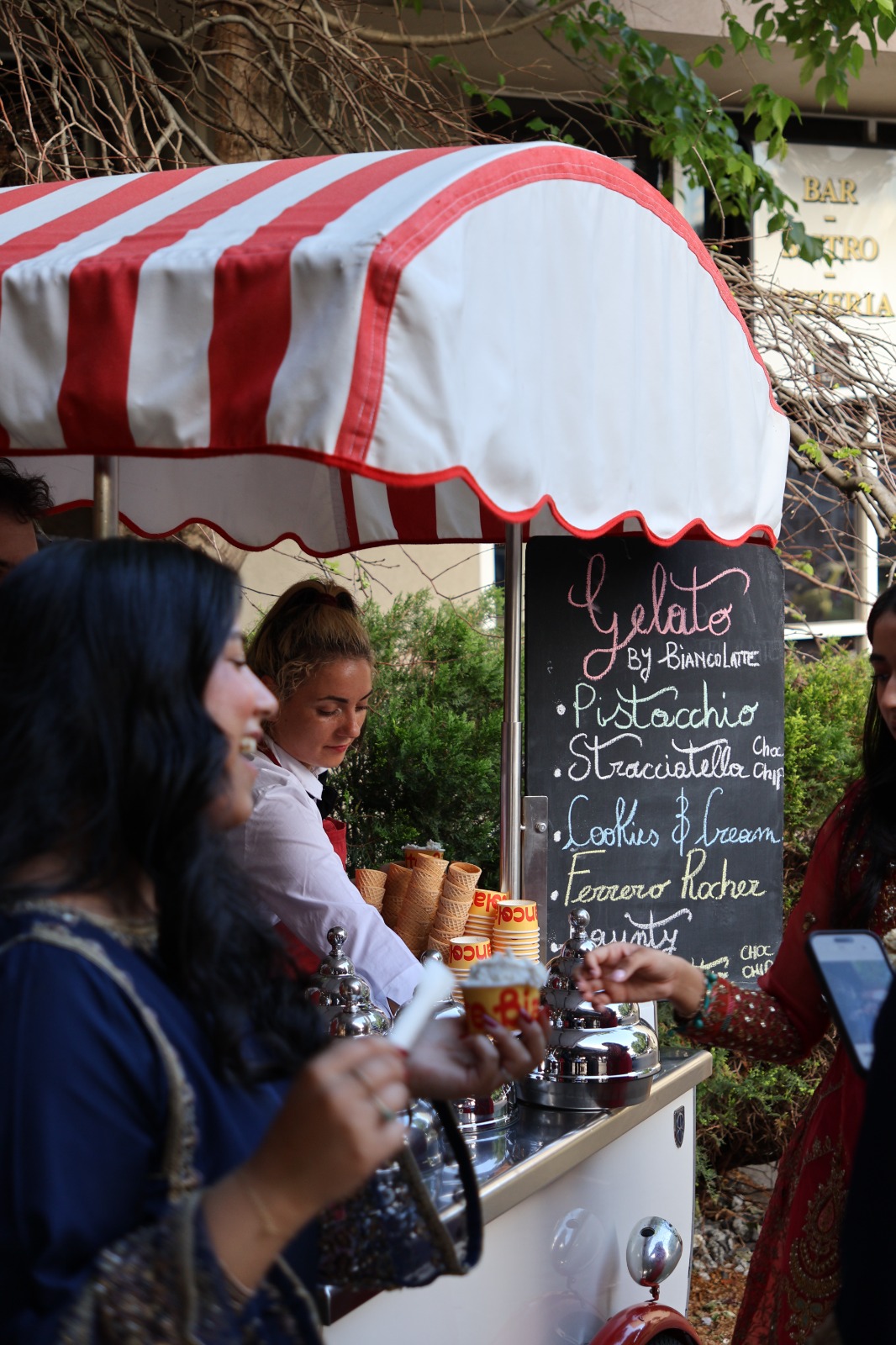 Guests collecting gelato from a striped cart