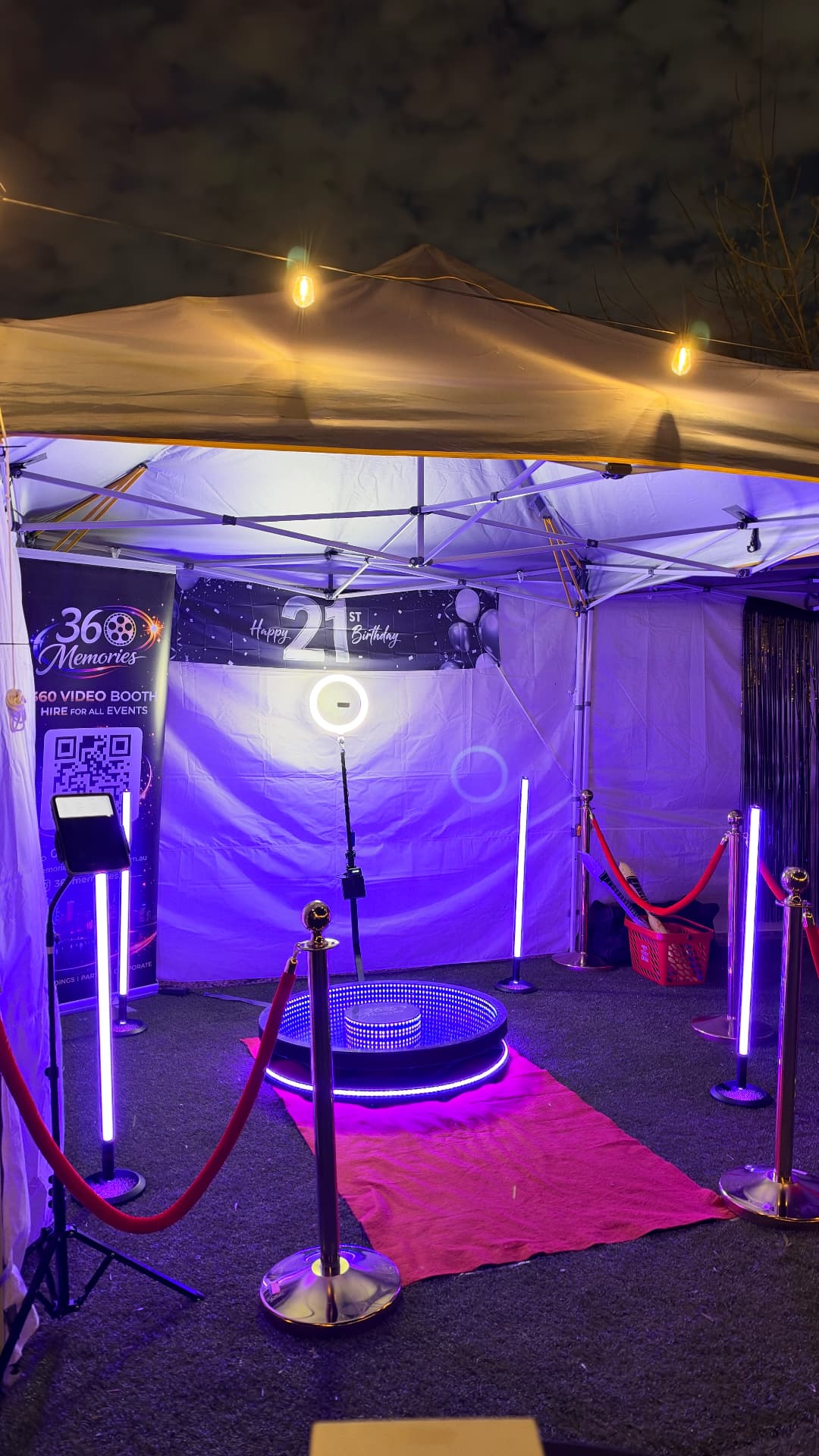 Outdoor 360 video booth under a canopy with purple lights and a red carpet