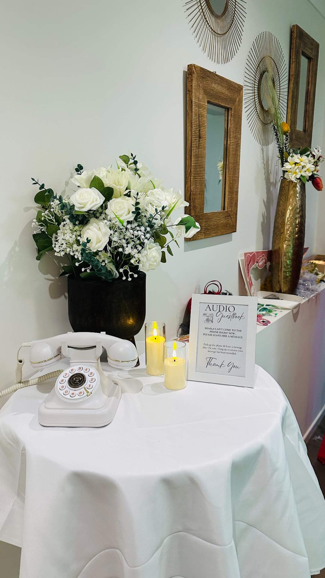 White audio guest book telephone on a styled table with flowers and candles